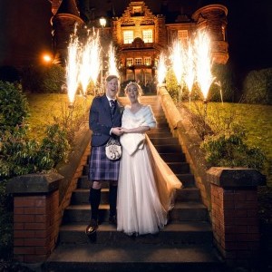 couple in front of house with fireworks