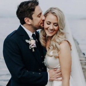 Bride and groom with groom kissing bride on head