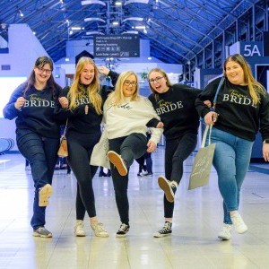 Press Page - Image of 5 visitors wearing team bride outfits on concourse